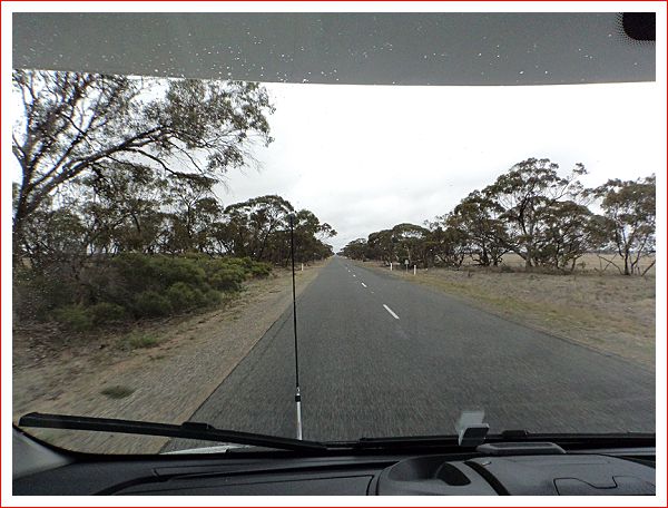 Long flat road ahead, in the drizzle.